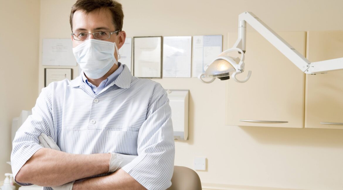 Dentist in exam room with mask on